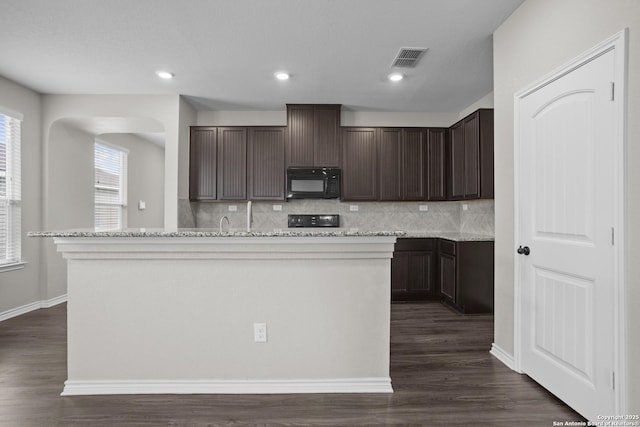 14606 Jocasta, San Antonio, TX 78245 - kitchen with black microwave, dark brown cabinetry, backsplash, dark wood-type flooring, and recessed lighting