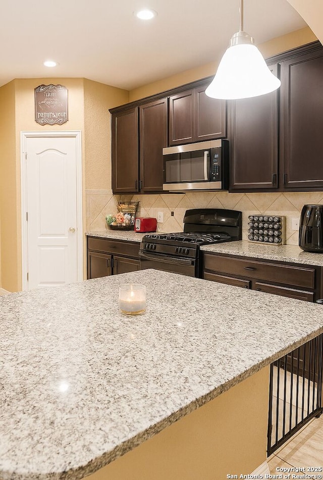 8910 Olmstead Park, Converse, TX 78109 - kitchen featuring stainless steel microwave, black gas range, dark brown cabinets, backsplash, and recessed lighting
