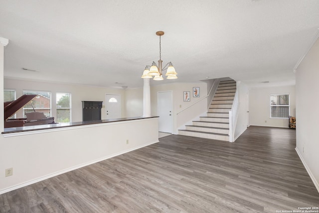 18706 Redriver, San Antonio, TX 78259 - unfurnished living room featuring wood finished floors, stairs, decorative columns, crown molding, and a textured ceiling