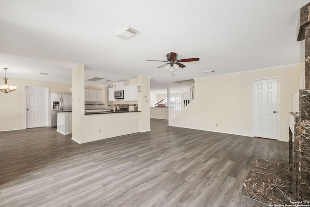 18706 Redriver, San Antonio, TX 78259 - unfurnished living room featuring a ceiling fan, dark wood-style floors, a fireplace, a chandelier, and stairs