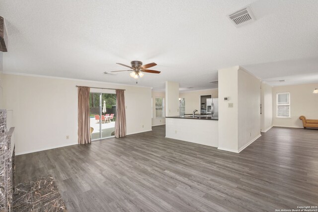 18706 Redriver, San Antonio, TX 78259 - unfurnished living room featuring dark wood-type flooring, ceiling fan, and crown molding