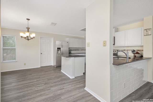18706 Redriver, San Antonio, TX 78259 - kitchen featuring stainless steel fridge, dark countertops, wood finished floors, a chandelier, and decorative backsplash