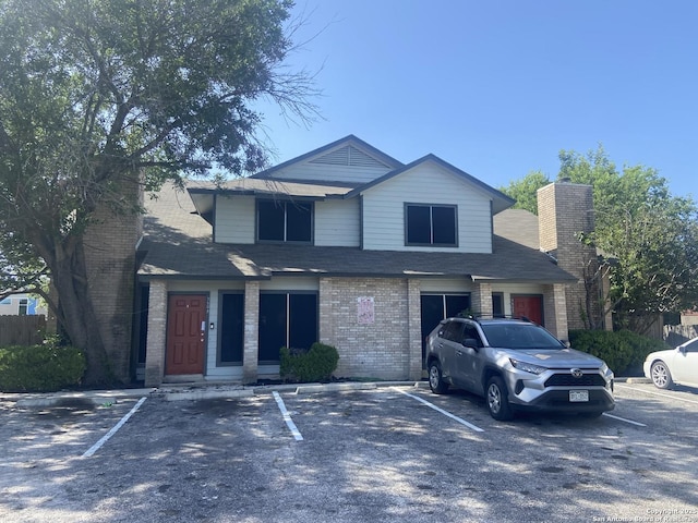 7502 Oak Chase, San Antonio, TX 78239 - view of front of house featuring uncovered parking, brick siding, a chimney, and a shingled roof