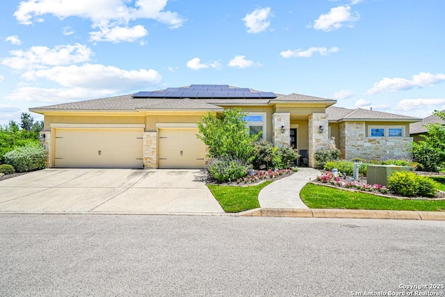 4603 Camden, San Antonio, TX 78261 - prairie-style home featuring stone siding, roof mounted solar panels, an attached garage, and driveway
