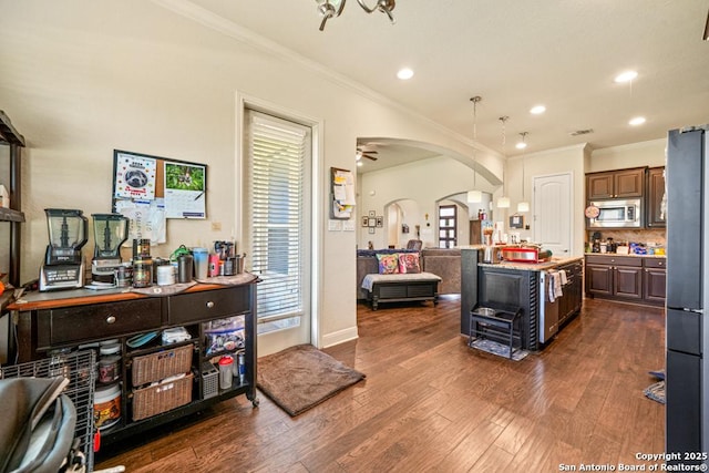 4603 Camden, San Antonio, TX 78261 - kitchen featuring stainless steel microwave, crown molding, open floor plan, freestanding refrigerator, and arched walkways