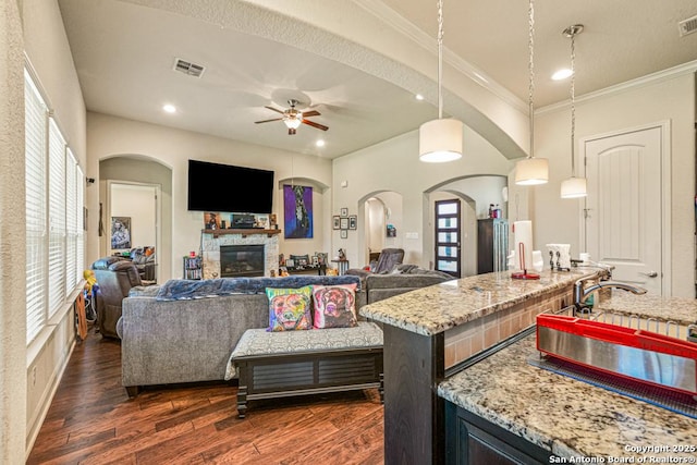 4603 Camden, San Antonio, TX 78261 - living area featuring a ceiling fan, healthy amount of natural light, a fireplace, dark wood finished floors, and ornamental molding