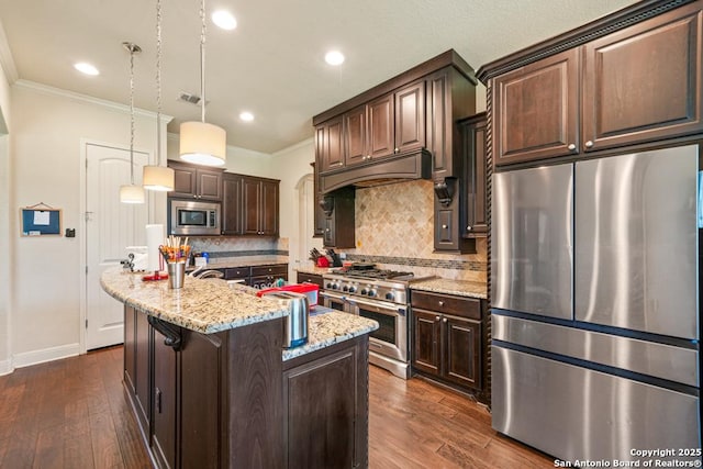 4603 Camden, San Antonio, TX 78261 - kitchen featuring appliances with stainless steel finishes, crown molding, dark brown cabinetry, custom exhaust hood, and dark wood-style flooring