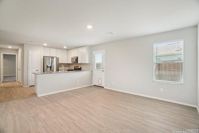 6407 Ignacio, San Antonio, TX 78220 - kitchen with appliances with stainless steel finishes, light wood finished floors, white cabinetry, recessed lighting, and open floor plan