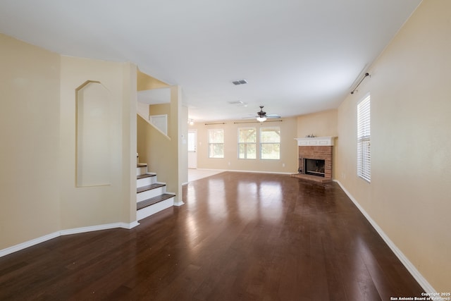 11922 Briarton Wls, San Antonio, TX 78254 - unfurnished living room with ceiling fan, wood finished floors, stairs, and a brick fireplace