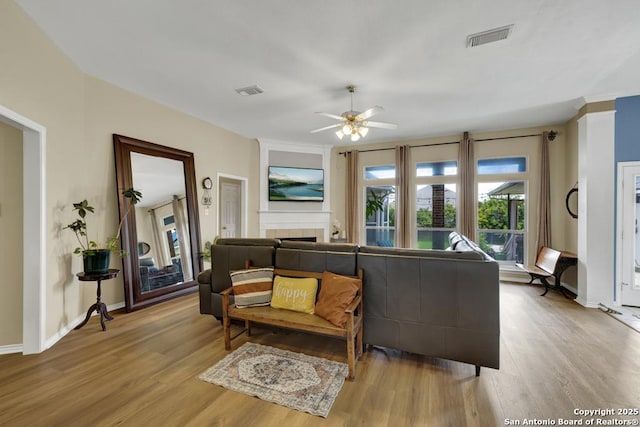 2363 Oak Pebble, New Braunfels, TX 78132 - living room with wood finished floors, ceiling fan, and a tile fireplace
