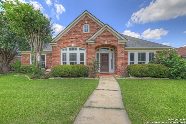 2363 Oak Pebble, New Braunfels, TX 78132 - traditional-style home featuring brick siding, a front yard, and roof with shingles