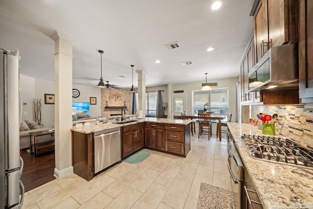 20926 Encino Dawn, San Antonio, TX 78259 - kitchen featuring stainless steel appliances, ornate columns, decorative backsplash, hanging light fixtures, and recessed lighting