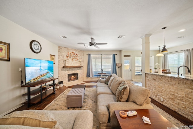 20926 Encino Dawn, San Antonio, TX 78259 - living room featuring dark wood-style flooring, healthy amount of natural light, a stone fireplace, and ceiling fan