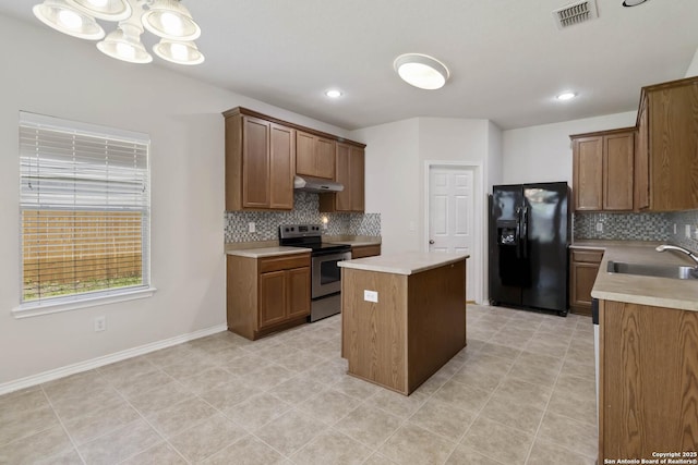 10107 Roseangel, Helotes, TX 78023 - kitchen featuring stainless steel electric range, black fridge, a center island, backsplash, and recessed lighting