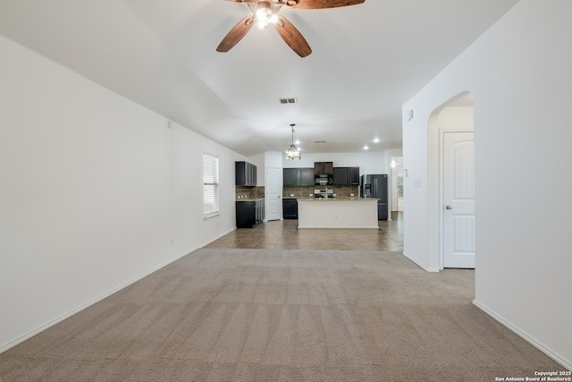 11750 Caraway, San Antonio, TX 78245 - unfurnished living room featuring ceiling fan, light carpet, arched walkways, and vaulted ceiling