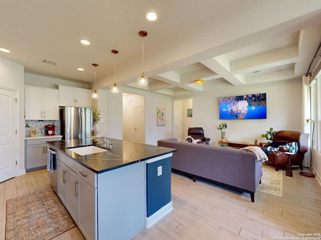 7621 Cypress, Boerne, TX 78015 - kitchen with stainless steel appliances, open floor plan, dark countertops, light wood-type flooring, and beam ceiling