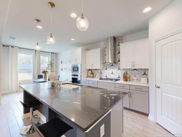 7621 Cypress, Boerne, TX 78015 - kitchen with wall chimney exhaust hood, appliances with stainless steel finishes, backsplash, an island with sink, and recessed lighting