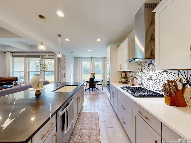 7621 Cypress, Boerne, TX 78015 - kitchen featuring stainless steel appliances, wall chimney exhaust hood, white cabinets, pendant lighting, and decorative backsplash