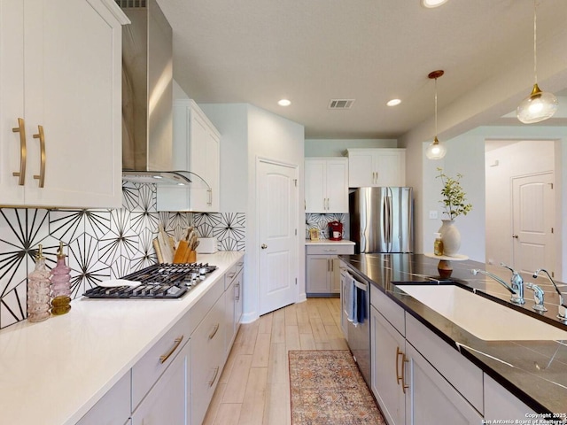 7621 Cypress, Boerne, TX 78015 - kitchen with appliances with stainless steel finishes, wall chimney range hood, white cabinetry, recessed lighting, and pendant lighting