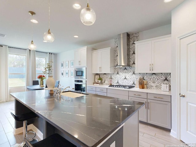7621 Cypress, Boerne, TX 78015 - kitchen with stainless steel appliances, wall chimney exhaust hood, backsplash, a center island with sink, and recessed lighting