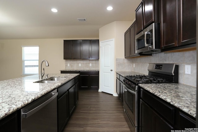 13027 Maestro Spark, San Antonio, TX 78252 - kitchen with appliances with stainless steel finishes, light stone countertops, dark wood-style floors, dark brown cabinets, and recessed lighting