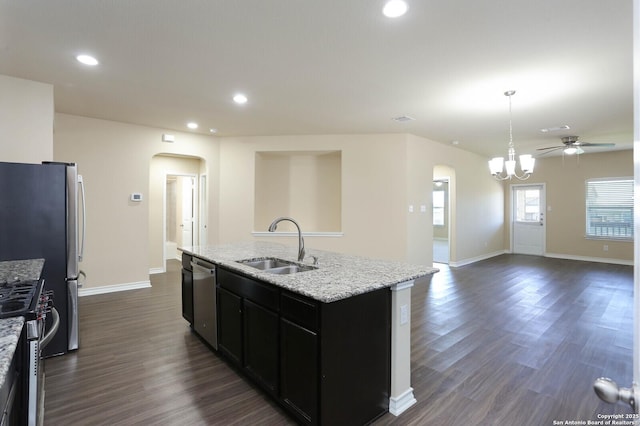13027 Maestro Spark, San Antonio, TX 78252 - kitchen featuring arched walkways, appliances with stainless steel finishes, ceiling fan, dark cabinets, and a center island with sink