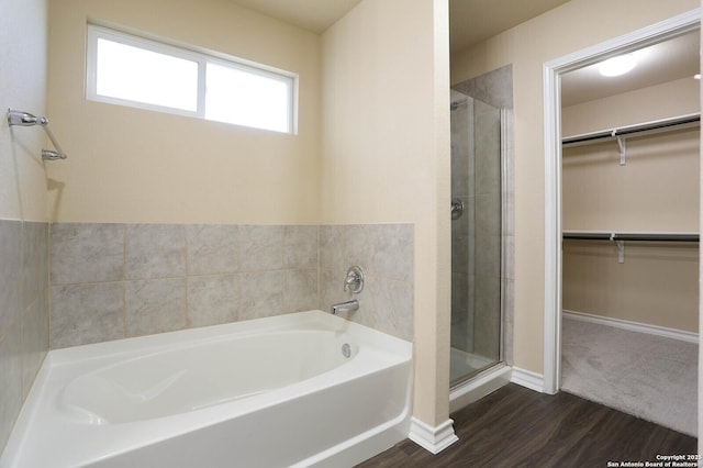 13027 Maestro Spark, San Antonio, TX 78252 - full bathroom featuring a bath, a walk in closet, a stall shower, and wood finished floors