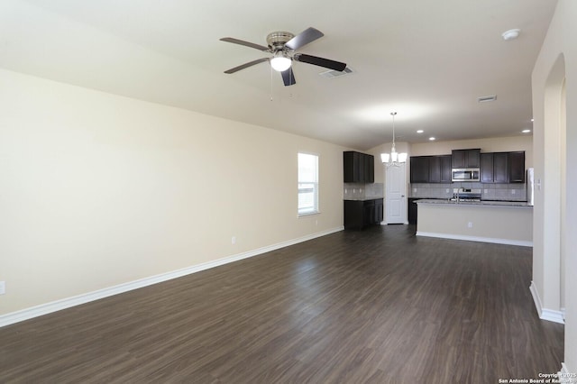 13027 Maestro Spark, San Antonio, TX 78252 - unfurnished living room featuring a ceiling fan, dark wood-type flooring, arched walkways, recessed lighting, and a chandelier