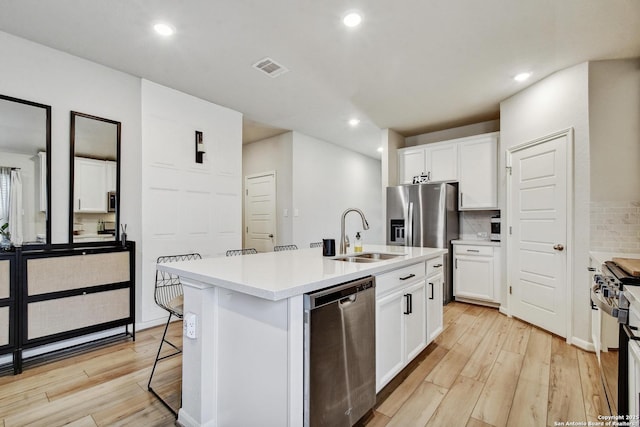 13019 Louberg, San Antonio, TX 78253 - kitchen featuring stainless steel appliances, light wood-style floors, a center island with sink, backsplash, and recessed lighting