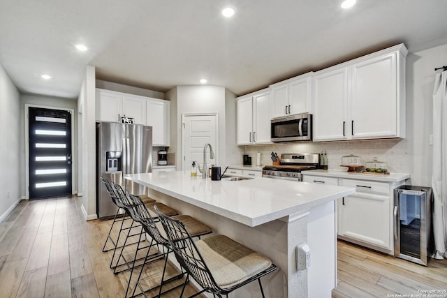 13019 Louberg, San Antonio, TX 78253 - kitchen with stainless steel appliances, wine cooler, backsplash, light wood-style flooring, and recessed lighting