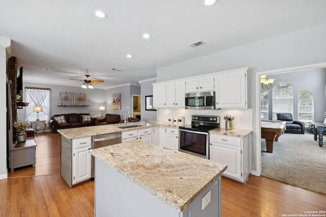 2723 Sierra Salinas, San Antonio, TX 78259 - kitchen with appliances with stainless steel finishes, open floor plan, a peninsula, a kitchen island, and white cabinetry
