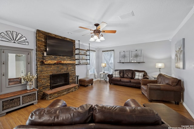 2723 Sierra Salinas, San Antonio, TX 78259 - living room with ornamental molding, a ceiling fan, a stone fireplace, and wood finished floors