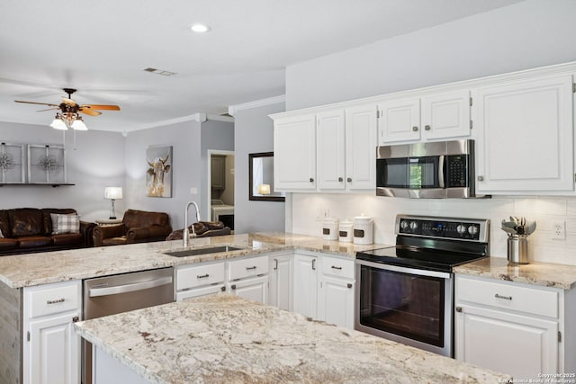 2723 Sierra Salinas, San Antonio, TX 78259 - kitchen featuring appliances with stainless steel finishes, a peninsula, open floor plan, tasteful backsplash, and ornamental molding