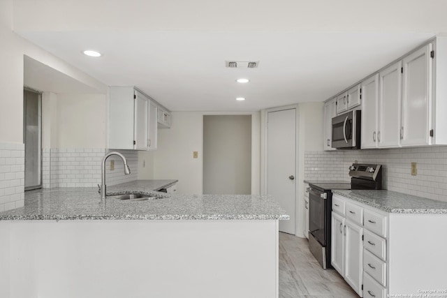 114 Crystal Cyn, Universal City, TX 78148 - kitchen with appliances with stainless steel finishes, a peninsula, light stone countertops, decorative backsplash, and recessed lighting