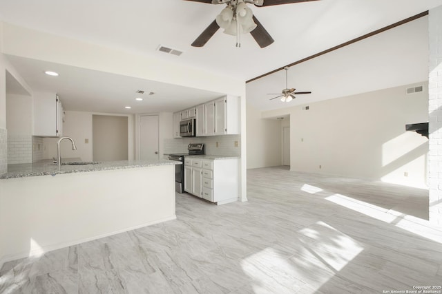 114 Crystal Cyn, Universal City, TX 78148 - kitchen featuring appliances with stainless steel finishes, a ceiling fan, tasteful backsplash, white cabinets, and light stone countertops