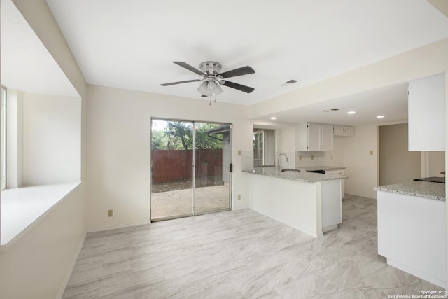 114 Crystal Cyn, Universal City, TX 78148 - kitchen with a peninsula, light stone counters, ceiling fan, recessed lighting, and decorative backsplash
