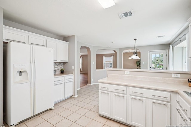 614 Granite Clf, San Antonio, TX 78251 - kitchen featuring white fridge with ice dispenser, arched walkways, white cabinetry, light countertops, and light tile patterned flooring