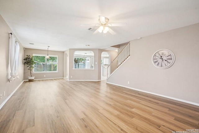614 Granite Clf, San Antonio, TX 78251 - unfurnished living room with ceiling fan, light wood finished floors, arched walkways, and stairway