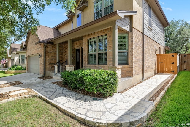 3535 Arroyo Grande, San Antonio, TX 78253 - view of side of home featuring a gate, brick siding, concrete driveway, and an attached garage