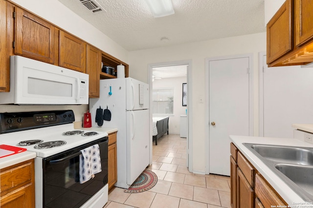 5322 Medical Unit A102, San Antonio, TX 78240 - kitchen with white appliances, brown cabinetry, light countertops, and a textured ceiling