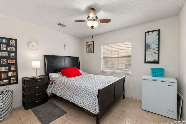 5322 Medical Unit A102, San Antonio, TX 78240 - bedroom featuring fridge, light tile patterned floors, ceiling fan, and a textured ceiling