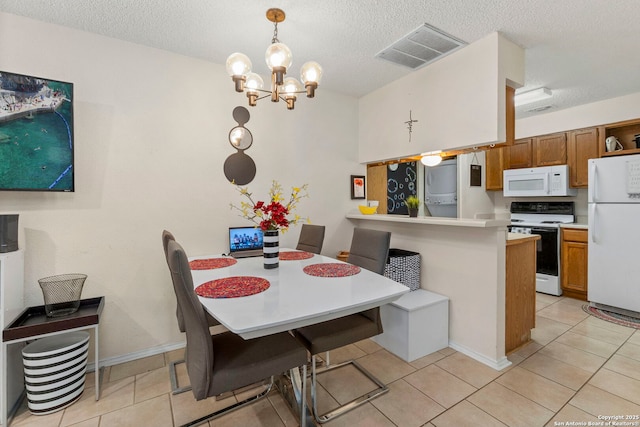 5322 Medical Unit A102, San Antonio, TX 78240 - dining area featuring a chandelier, a textured ceiling, light tile patterned floors, and washer / dryer