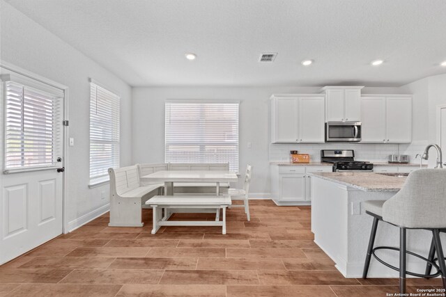 3415 Iron Cyn, Bulverde, TX 78163 - kitchen featuring stainless steel appliances, backsplash, white cabinetry, recessed lighting, and light stone counters