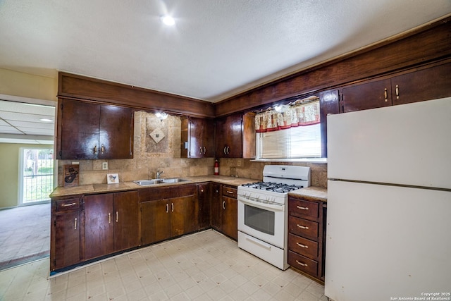 606 W Baetz Blvd, San Antonio, TX 78221 - kitchen featuring white appliances, dark brown cabinetry, light flooring, and light countertops