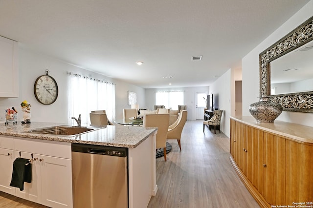 10746 Margarita Loop, Converse, TX 78109 - kitchen with stainless steel dishwasher, white cabinets, light wood-type flooring, light stone countertops, and open floor plan