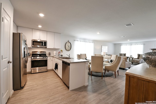 10746 Margarita Loop, Converse, TX 78109 - kitchen featuring stainless steel appliances, a peninsula, open floor plan, white cabinets, and recessed lighting