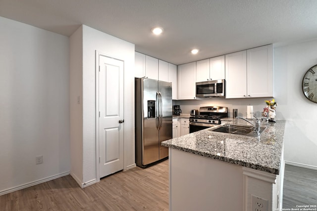 10746 Margarita Loop, Converse, TX 78109 - kitchen with appliances with stainless steel finishes, a peninsula, light wood finished floors, light stone countertops, and recessed lighting
