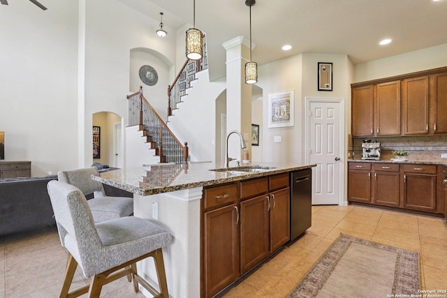 3403 Navajo Peace, San Antonio, TX 78261 - kitchen with arched walkways, dishwashing machine, stone countertops, light tile patterned floors, and a kitchen breakfast bar