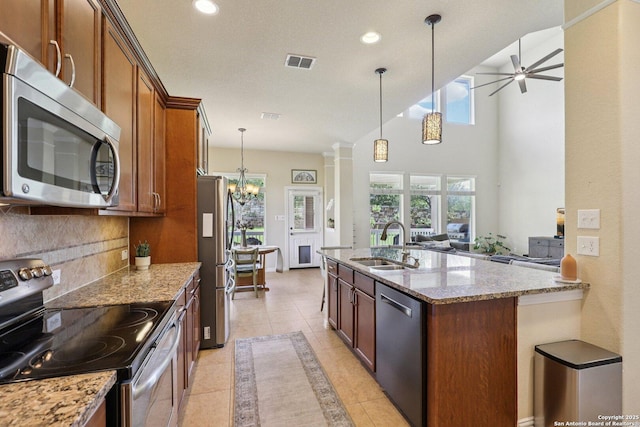 3403 Navajo Peace, San Antonio, TX 78261 - kitchen with stainless steel appliances, light stone counters, tasteful backsplash, hanging light fixtures, and ceiling fan