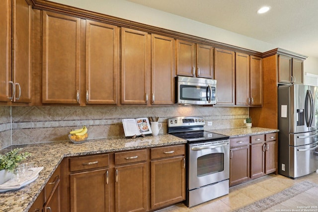 3403 Navajo Peace, San Antonio, TX 78261 - kitchen with stainless steel appliances, brown cabinets, light stone countertops, decorative backsplash, and recessed lighting